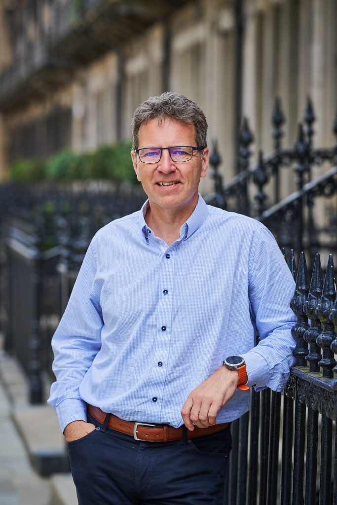 Man wearing a light blue shirt and dark blue jeans.