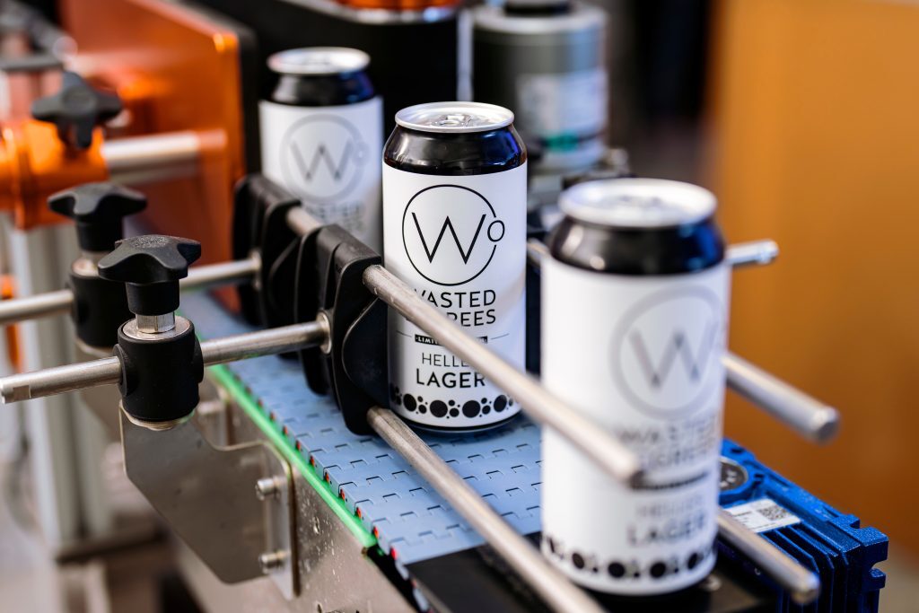 three white and black coloured can of lager.